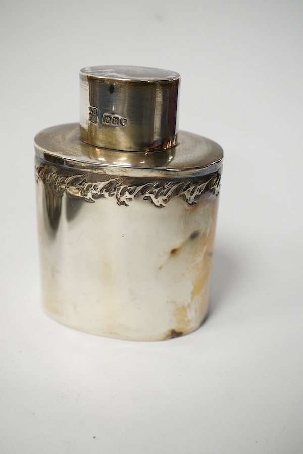 An Edwardian rectangular embossed silver mounted note case, leather lined, Goldsmiths & Silversmiths Co Ltd, London, 1901, 10.3cm, an oval silver tea caddy and cover and an Indian white metal circular box. Condition - po